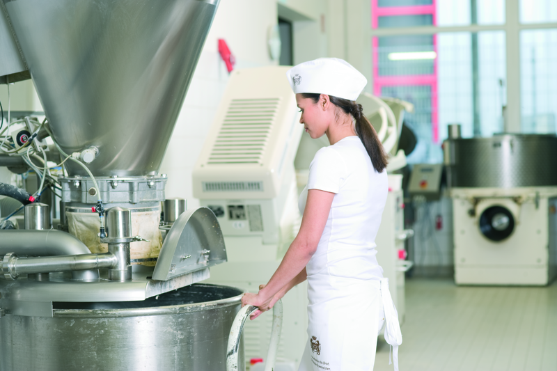 Frau in der Backstube am Mischgerät