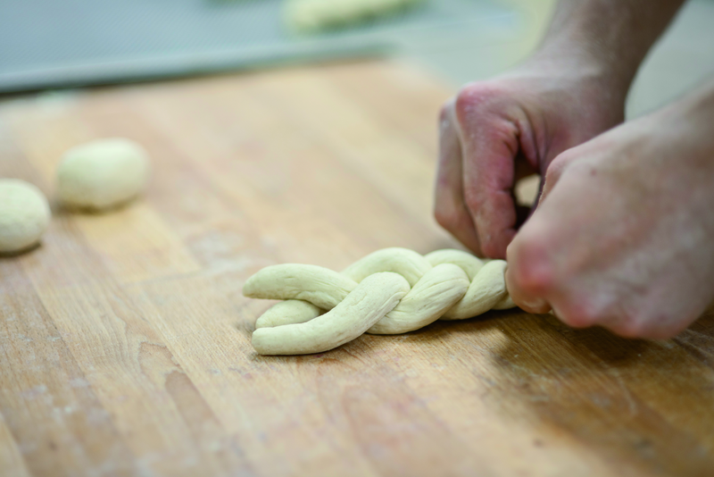 Bäcker flechtet Hefezöpfe