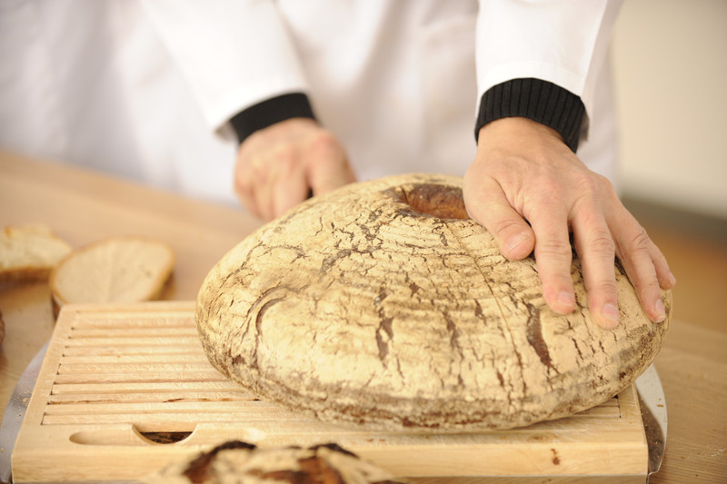 Bäcker schneidet Rundbrot
