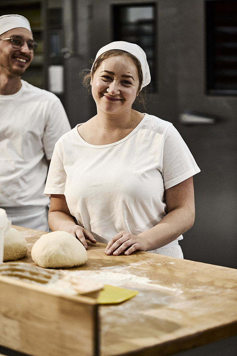 Bäckerin beim Teig Kneten