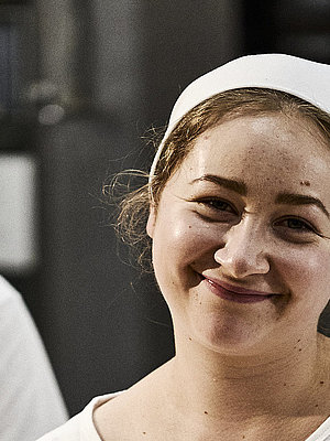 Bäckerin beim Teig Kneten