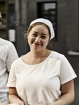 Bäckerin beim Teig Kneten