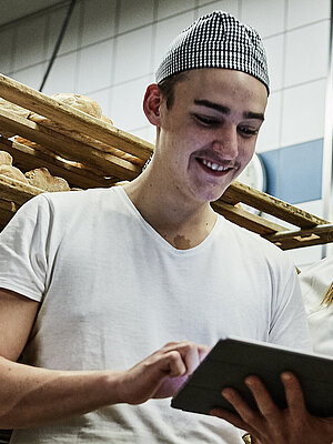 Zwei Bäcker besprechen etwas und schauen auf ein Klemmbrett