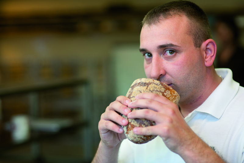 Bäcker riecht an Brot