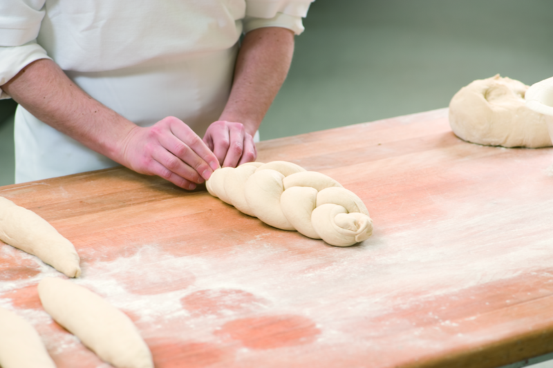 Bäcker formt Teig zu einem Zopf