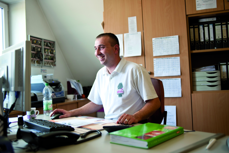 Bäcker sitzt am Computer