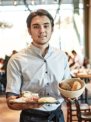 Bäckereifachverkäufer bedient Kunden