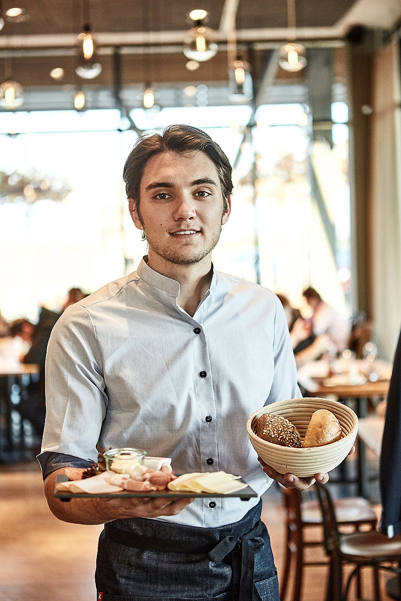 Bäckereifachverkäufer bedient Kunden
