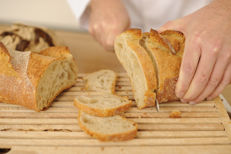 Bäcker schneidet Brot