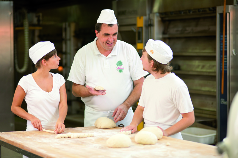 Bäckermeister erklärt Azubis Zubereitung von Teigwaren