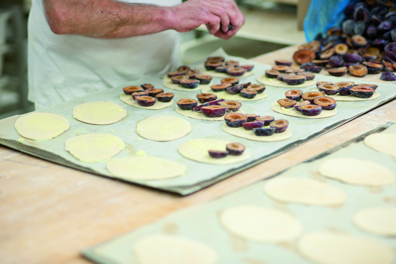 Teigrohlinge werden mit Pflaumen belegt