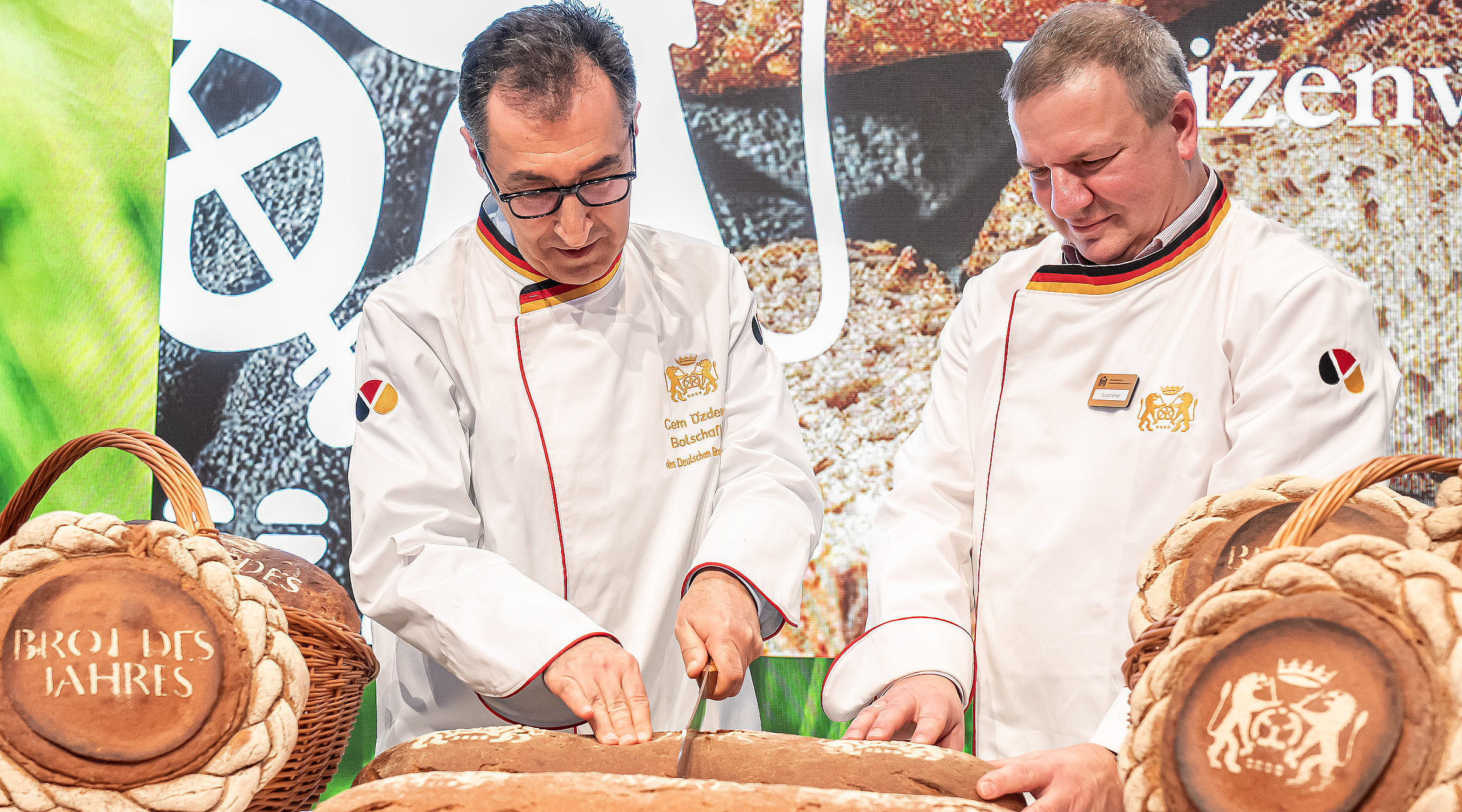 Bäcker zerteilt das Brot bei der Grünen Woche