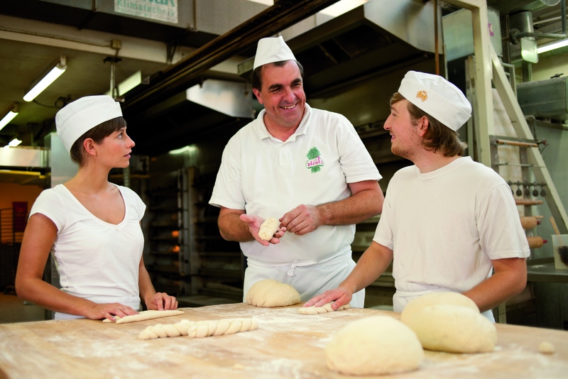 Bäckermeister erklärt Azubis Zubereitung von Teigwaren