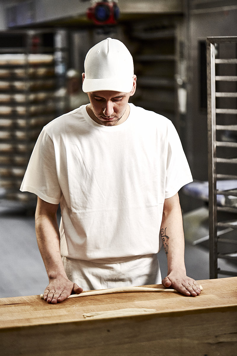 Bäcker Azubi formt Brezel