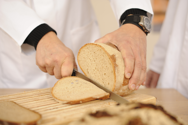 Bäcker schneidet Weizenbrot