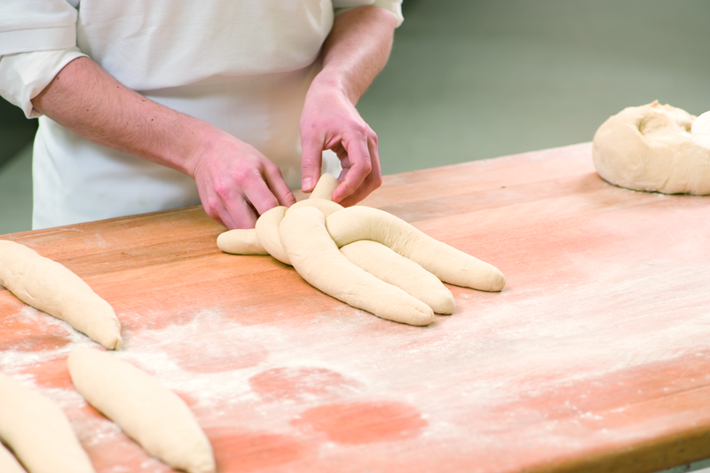 Bäcker formt Teig zu einem Zopf