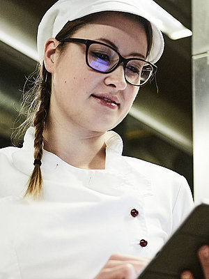 Bäckerin schreibt was auf ein Klemmbrett