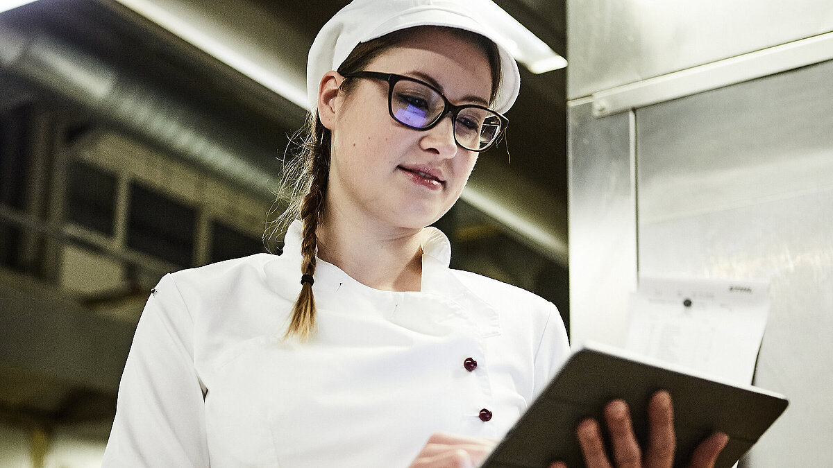 Bäckerin schreibt was auf ein Klemmbrett