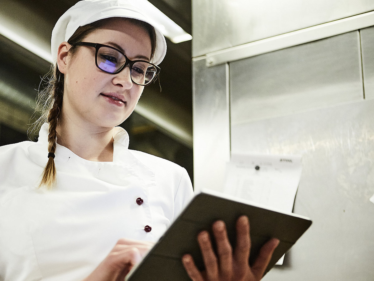 Bäckerin schreibt was auf ein Klemmbrett