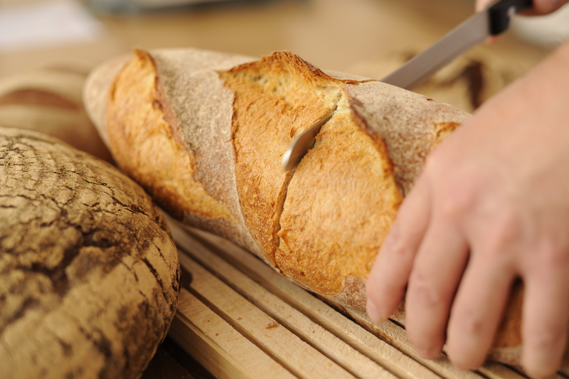 Bäcker schneidet Brot