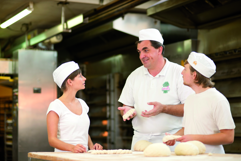 Bäckermeister erklärt Azubis Zubereitung von Teigwaren