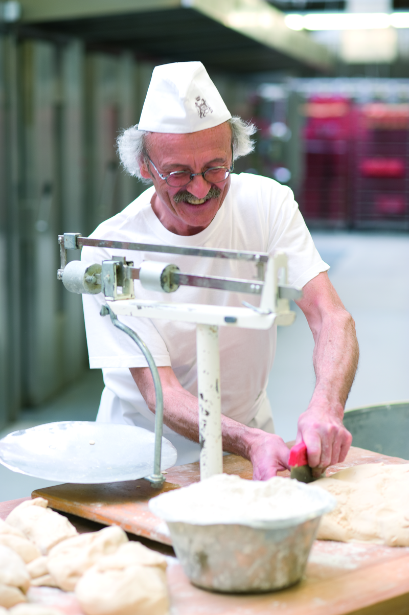 Bäckermeister trennt Teig zum Wiegen mit einem Abstecher