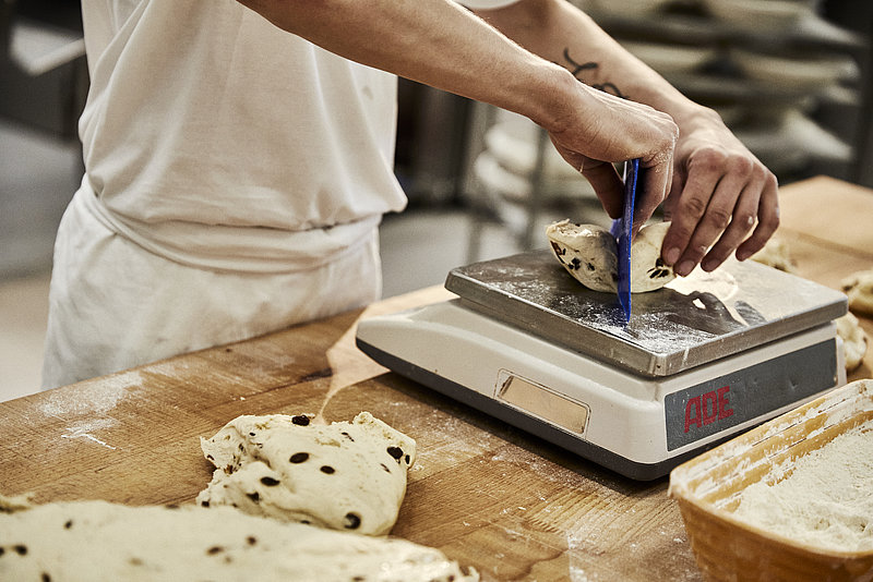 Bäcker portioniert Teig, Waage