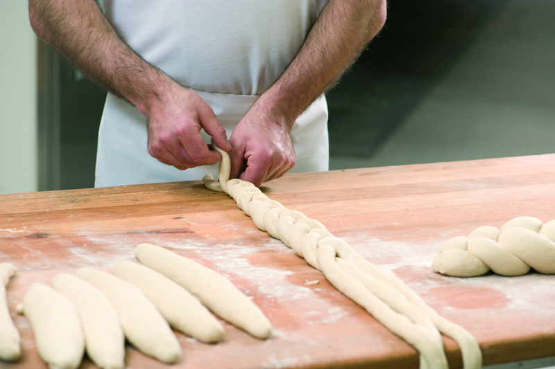 Bäcker formt Teig zu einem Zopf