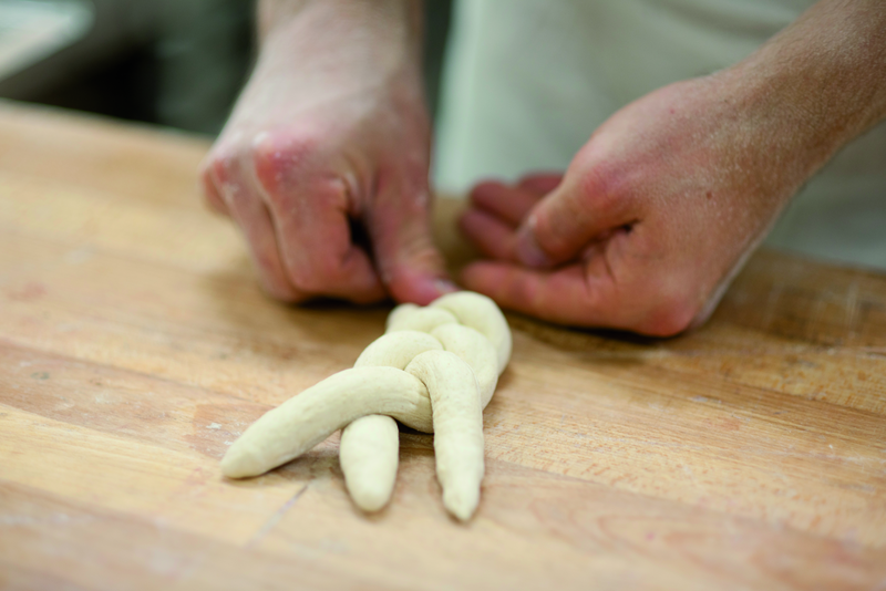 Bäcker flechtet Hefezöpfe