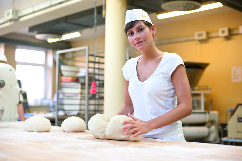 Bäckerauszubildende knetet Teig