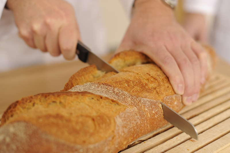 Bäcker schneidet Brot