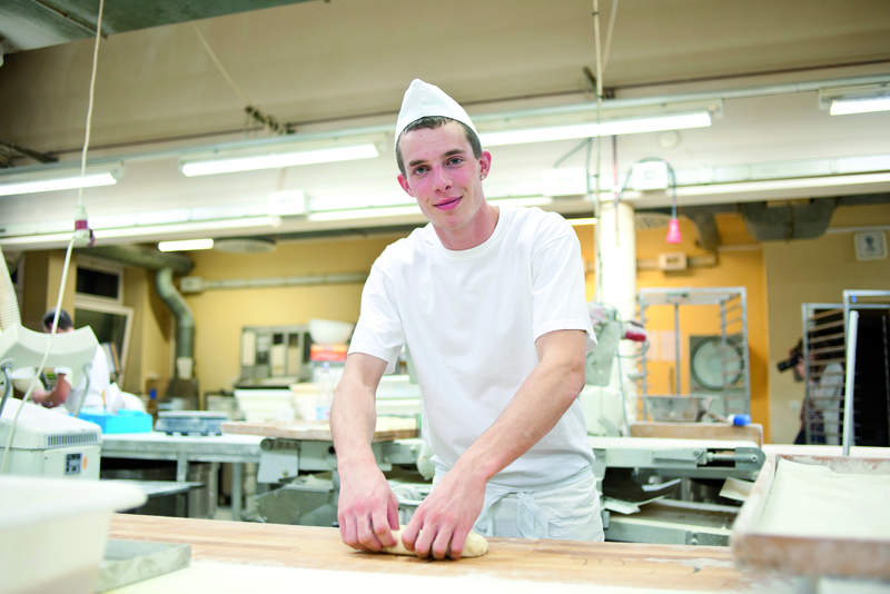 Bäckergeselle knetet Teig