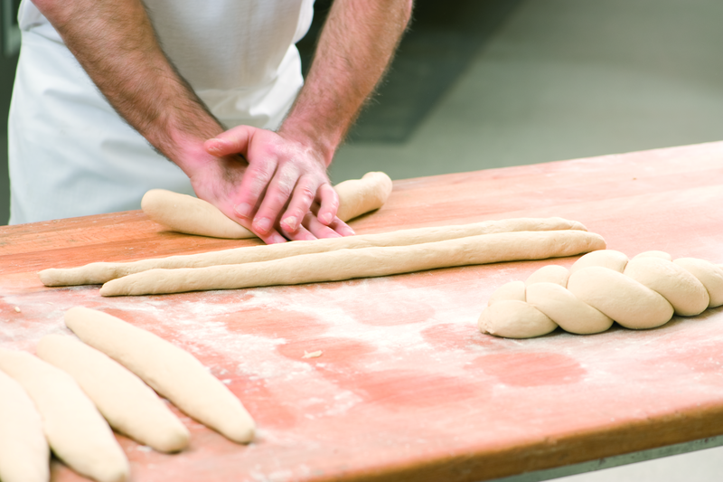 Bäcker formt Teig zu einem Zopf