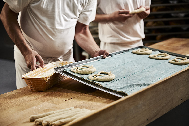 Bäcker formen Brezeln, Blech