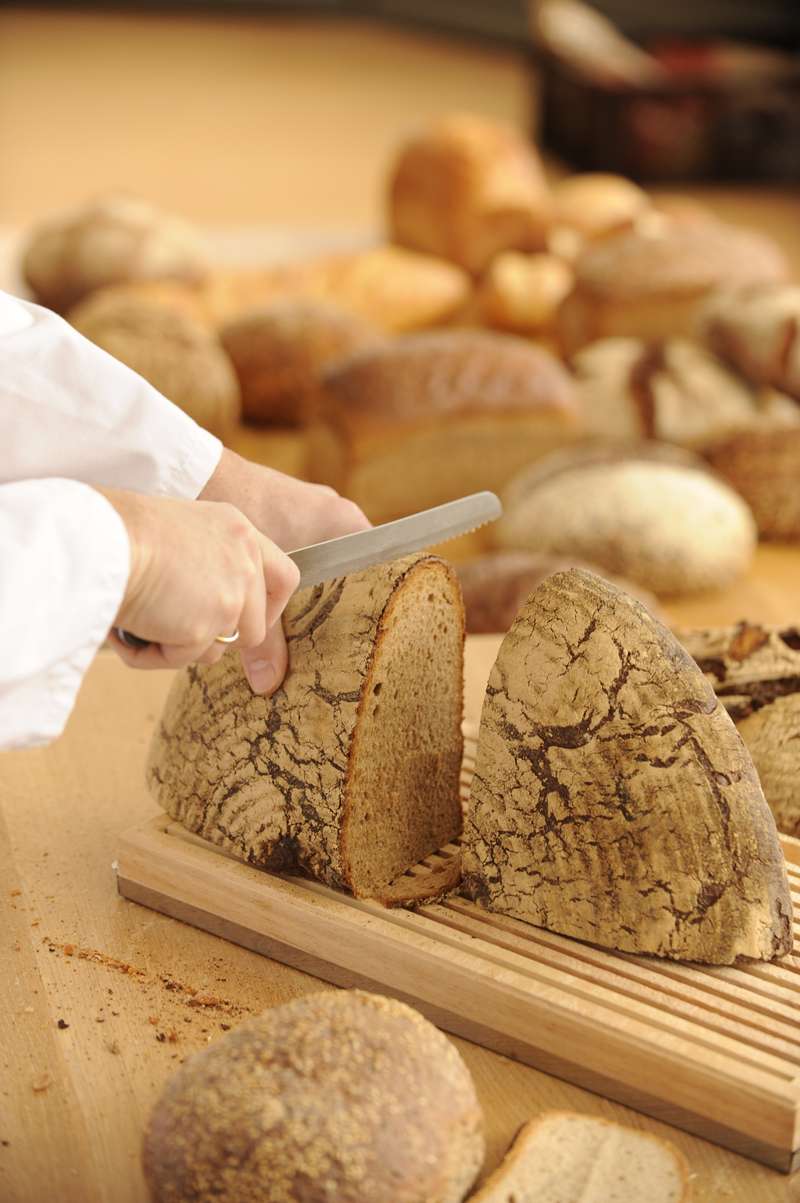 Bäcker schneidet Rundbrot