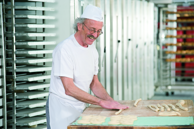 Bäckermeister beim Formen von Teig