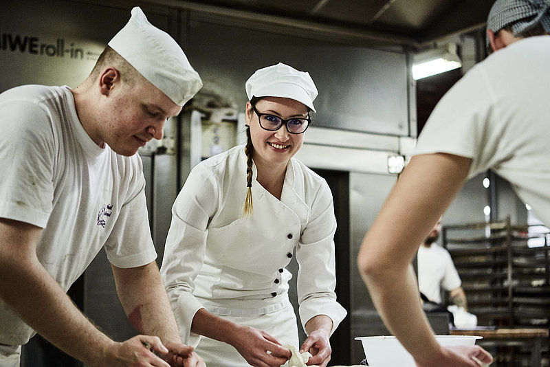 Bäcker mit Azubine bei der Teigverarbeitung