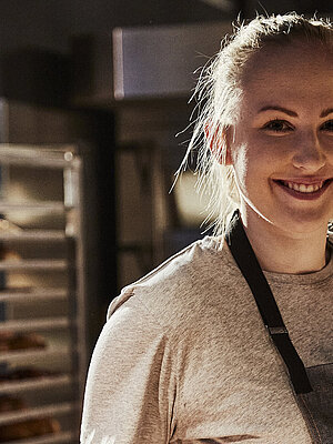 Bäckereifachverkäuferin schaut in die Kamera