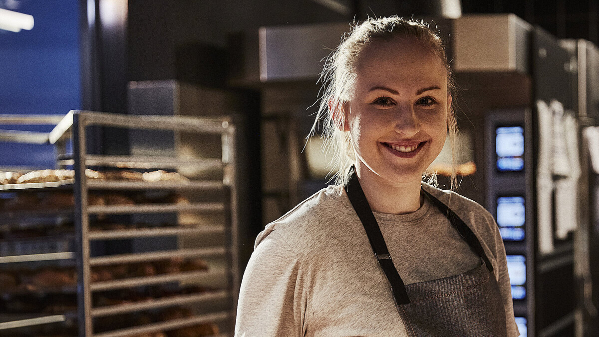 Bäckereifachverkäuferin schaut in die Kamera