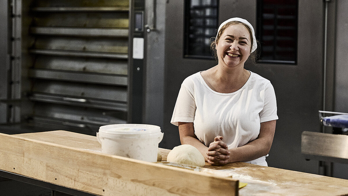 Bäckerin beim Teig kneten