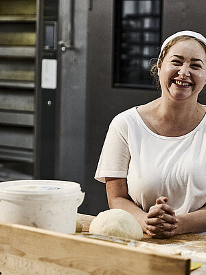 Bäckerin beim Teig kneten