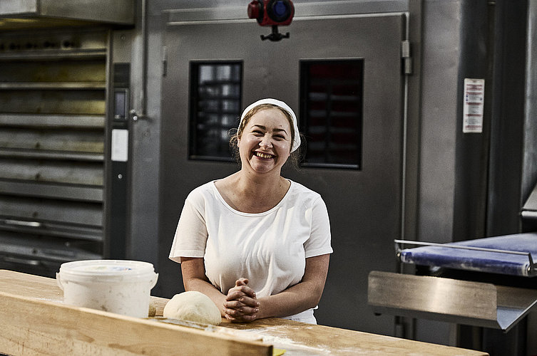 Bäckerin beim Teig kneten