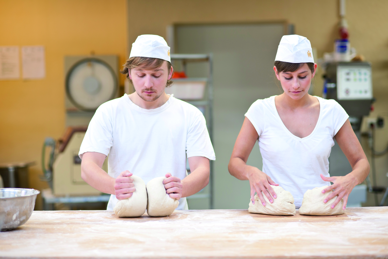 Bäckerauszubildende kneten Teig
