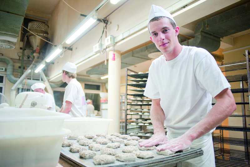 Bäckergeselle formt Brötchenteig