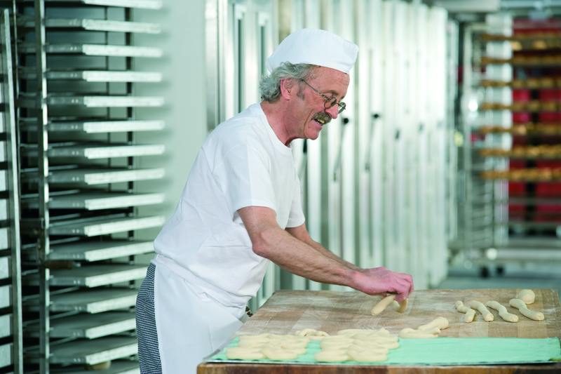 Bäckermeister formt Teig zu einer Brezel