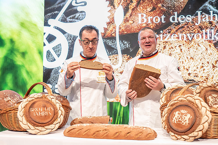 Zwei Bäcker mit Brot in der Hand bei der Grüne Woche 