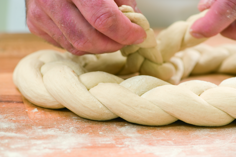 Bäcker formt Teig zu einer Bretzel