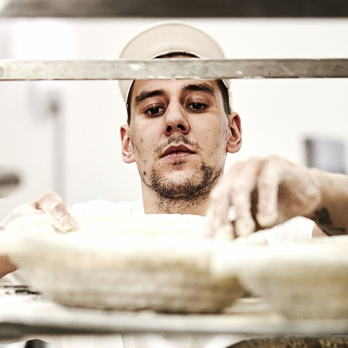 Bäcker prüft ein Gärkorb für Brote