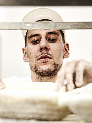 Bäcker prüft ein Gärkorb für Brote