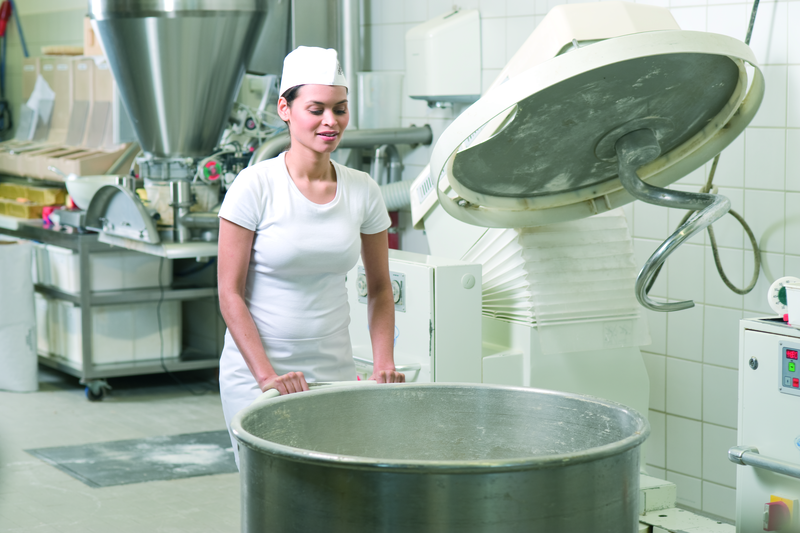 Bäckergesellin am Knetgerät